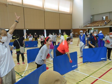 �n�ʂɒu���ꂽ�����ɎQ���҂��g���̋��𓊂�����Ă��܂�