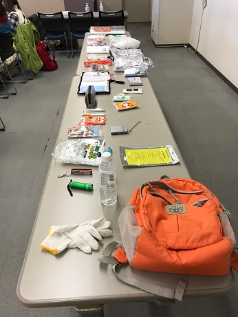 リュック・水のベットボトル・携帯ラジオ・懐中電灯・軍手などの防災グッズ