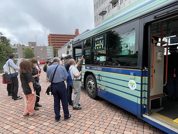 バスの側面と参加者の後ろ姿が写っています