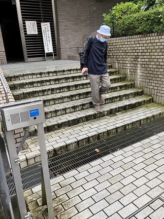 古い階段の段差を確認しながら下る男性参加者