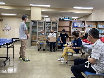 講師の説明を聞きながらラケットの感触を確かめている男性参加者