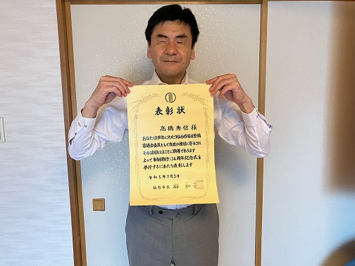 橋会長が表彰状を胸の前に掲げている正面からの写真