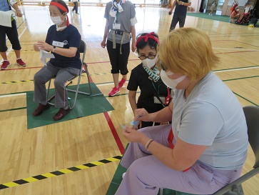 赤いハチマキをして紙をちぎっている女性参加者