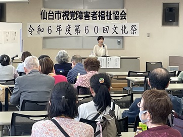 テーブルを前にマイクを持って話をする高橋梨佳氏