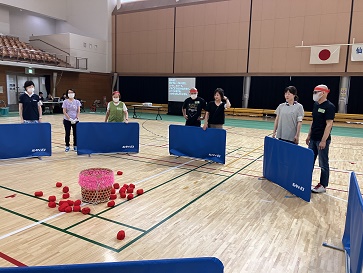 ���ɒu���ꂽ�Ăɋʂ𓊂���j���Q���ҁA�ׂɃT�|�[�g����w���p�[����