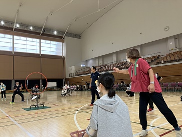 輪の中に向かってフライングディスクを投げている女性参加者