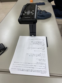 専用台の上にセンスプレーヤーを乗せ下に置いた印刷物の読み取り